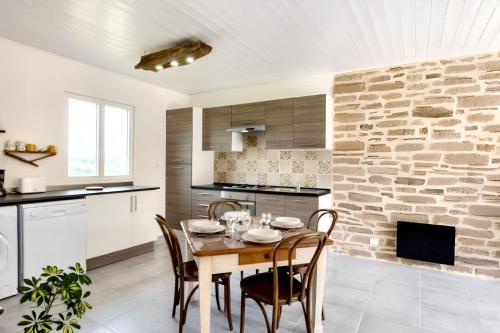 une cuisine et une salle à manger avec une table et des chaises dans l'établissement Maison chaleureuse à Fossemagne avec jardin et terrasse, à Fossemagne