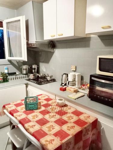 - une cuisine avec une table et une nappe dans l'établissement Maison accueillante à Montluçon avec jardin privatif, à Montluçon