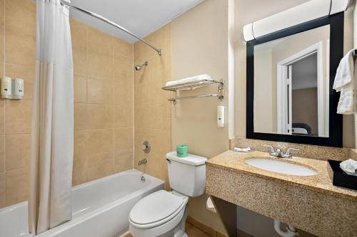 a bathroom with a toilet and a sink and a tub at Quality Inn Fort Myers Cape Coral in Fort Myers