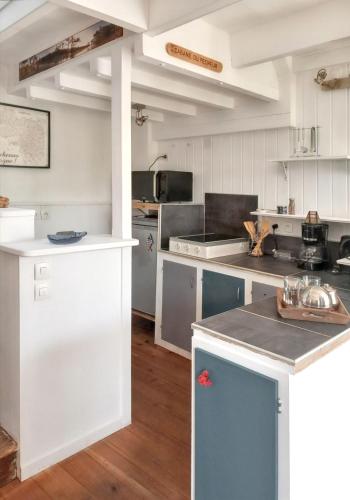 une cuisine avec des armoires blanches et un comptoir dans l'établissement Maison accueillante à Camaret-sur-Mer - Jardin spacieux 38 m², à Camaret-sur-Mer