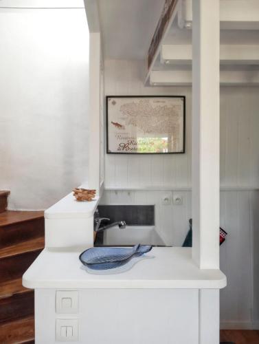 a white kitchen with a sink in a room at Maison accueillante à Camaret-sur-Mer - Jardin spacieux 38 m² in Camaret-sur-Mer