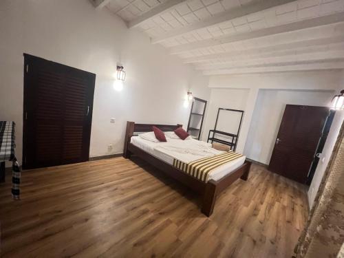 a bedroom with a bed and a wooden floor at VillaWatuna in Unawatuna