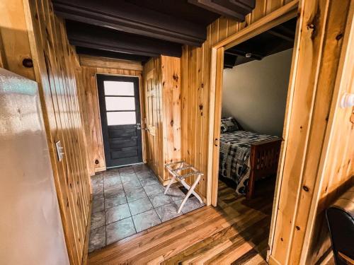 an empty hallway in a log cabin with a door at Whispering Waters, Hocking Hills, Hot Tub, Pond in Rockbridge