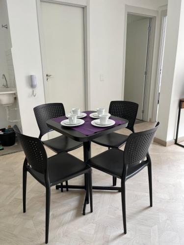 a black table with four chairs and a purple table andasteryasteryasteryasteryastery at LK Centro 3 in Belo Horizonte