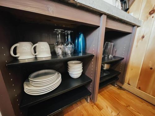 a shelf with plates and dishes on it at Whispering Waters, Hocking Hills, Hot Tub, Pond in Rockbridge