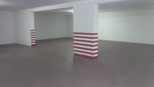 an empty room with red and white stripes on columns at Hotel Route 9 in Cadeo