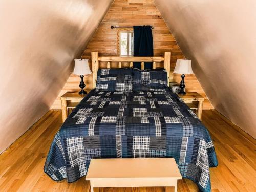 a bedroom with a bed and two tables in a room at Whispering Waters, Hocking Hills, Hot Tub, Pond in Rockbridge