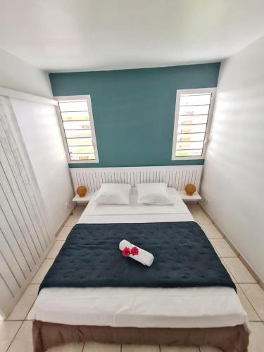 ein Schlafzimmer mit einem großen Bett mit einer Flasche in der Unterkunft Charmant appartement à La Trinité avec piscine partagée - 40 m² in La Trinité