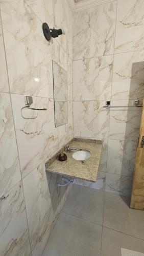 a bathroom with a sink and a shower at Pousada Bella Juquehy in Juquei