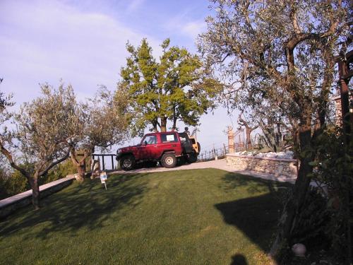 a red truck is parked in a yard at B&B Al Cristo in SantʼAmbrogio di Valpolicella