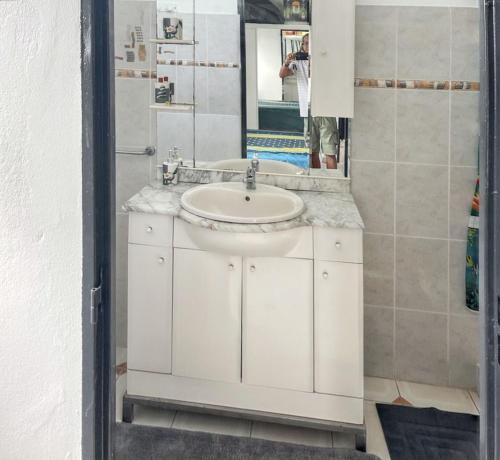 a bathroom with a white sink and a mirror at Villa charmante près de Saint-Esprit avec piscine privée in Quartier Monplaisir