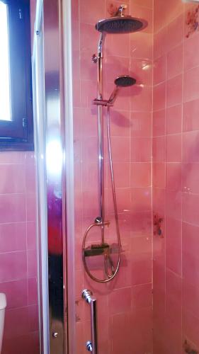 La salle de bains est pourvue d'une douche et de carrelage rose. dans l'établissement Appartement spacieux à Mimizan, 42 m², proche plage - 6 pers !, à Mimizan