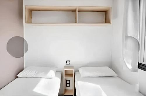 two beds in a small room with white walls at Bungalow confortable à Nans-les-Pins avec piscine partagée in Nans-les-Pins