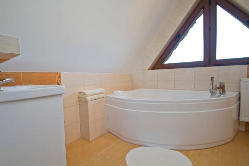 a white bath tub in a bathroom with a window at Willa Bystra in Kościelisko