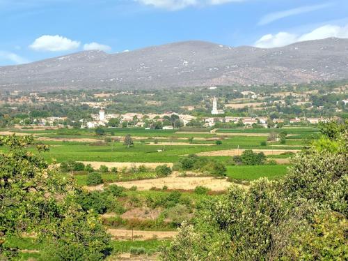 a view of a green field with mountains in the background at Villa Charmante à Pompignan avec Piscine et Jardin in Pompignan