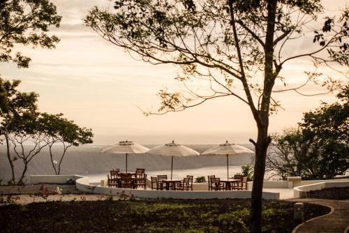 a patio with tables and umbrellas with a view at Pacaya Lodge and Spa in La Laguna