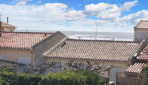 a view of the ocean from the roofs of houses at Appartement charmant à Fleury - 30 m² - Vue sur la mer in Fleury