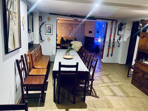 a dining room with a table and wooden chairs at Dom Na Widoku w górach Szczyrk in Szczyrk
