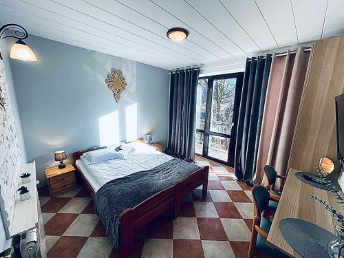 a bedroom with a bed and a large window at Dom Na Widoku w górach Szczyrk in Szczyrk