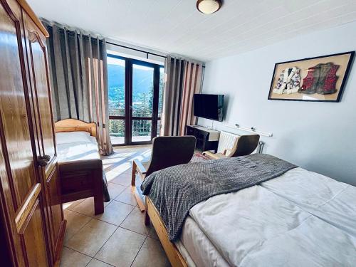 a bedroom with a bed and two chairs and a television at Dom Na Widoku w górach Szczyrk in Szczyrk