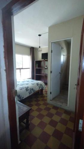 a bedroom with a bed and a mirror in a room at Hospedaje Rocha in Ica