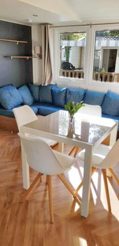 - une table à manger blanche et des chaises dans le salon dans l'établissement Bungalow chaleureux à Saint-Jean-de-Monts avec piscine partagée., à Saint-Jean-de-Monts