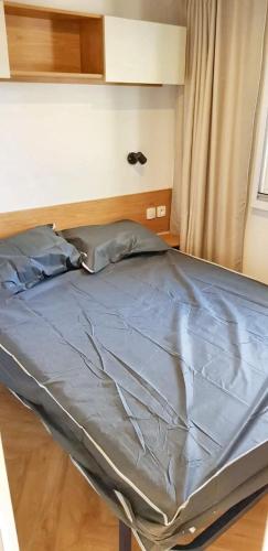 un lit dans une chambre avec un cadre de lit dans l'établissement Bungalow chaleureux à Saint-Jean-de-Monts avec piscine partagée., à Saint-Jean-de-Monts