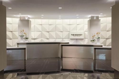 a lobby with a reception desk and a wall of tiles at The Godfrey Hotel Boston in Boston