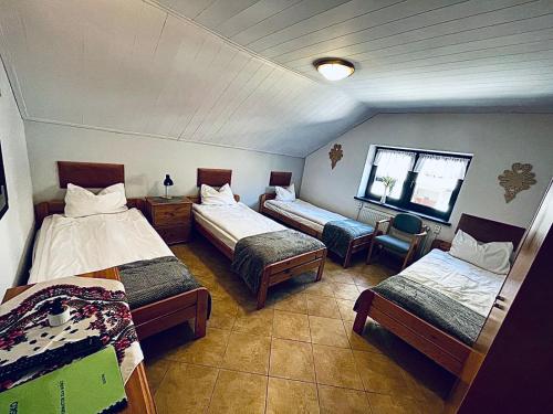 a room with three beds and a window at Dom Na Widoku w górach Szczyrk in Szczyrk