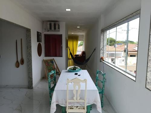 a dining room with a table and chairs and a window at Casa Praia de Conceição Barra-ES in Conceição da Barra