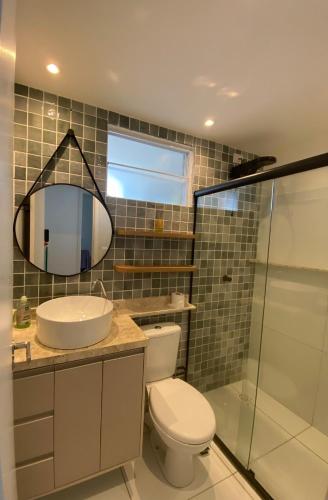 a bathroom with a toilet and a sink and a mirror at Solar Aruana, Aracaju, Aeroporto, Orla de Atalaia e Praia in Aracaju