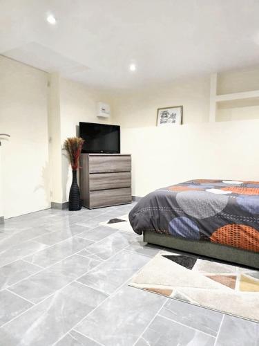 a bedroom with a bed and a flat screen tv at Studio charmant à Noisy-le-Sec de 22 m² avec terrasse in Noisy-le-Sec