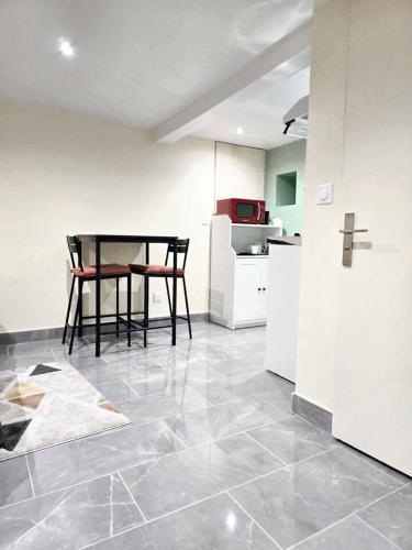 a kitchen with a table and a kitchen with a counter at Studio charmant à Noisy-le-Sec de 22 m² avec terrasse in Noisy-le-Sec