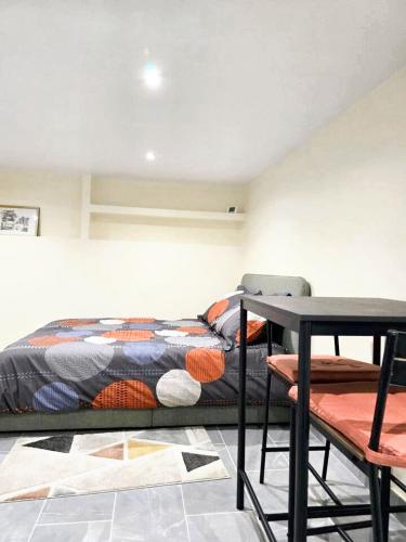 a bed in a room with a table and a bed at Studio charmant à Noisy-le-Sec de 22 m² avec terrasse in Noisy-le-Sec