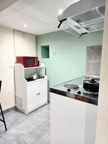 a kitchen with a stove and a microwave at Studio charmant à Noisy-le-Sec de 22 m² avec terrasse in Noisy-le-Sec
