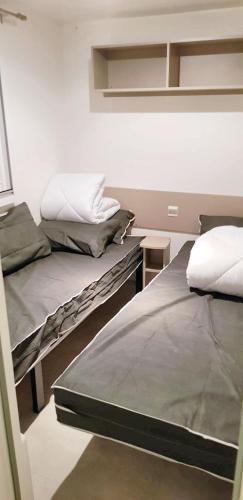 une chambre avec deux lits et une table dans l'établissement Bungalow confortable à Saint-Jean-de-Monts avec piscine partagée, à Saint-Jean-de-Monts