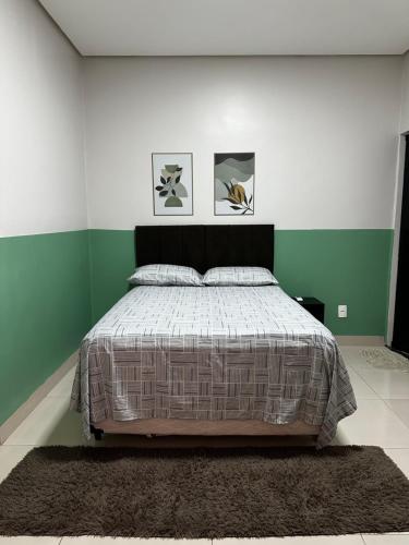 a bedroom with a bed with green and white walls at Casa 05 próximo ao centro Delior 2 in Palmas