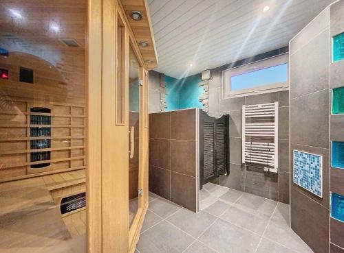 La salle de bains est pourvue d'une douche et d'une grande fenêtre. dans l'établissement Villa Neuvecelle Piscine Sauna, à Neuvecelle