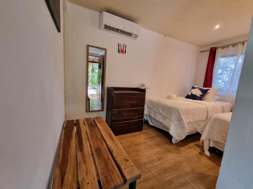 a bedroom with two beds and a wooden table at Pinilla Highlands Incredible mountain views in Tamarindo