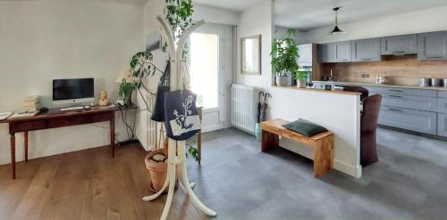 Cette chambre dispose d'une cuisine avec une table et des plantes. dans l'établissement Maison de charme à Grandcamp-Maisy avec vue sur la mer., à Grandcamp-Maisy