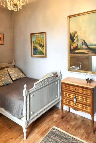 une chambre avec un lit, une commode et un miroir dans l'établissement Maison charmante au cœur de Sainte-Croix-du-Mont avec jardin, à Sainte-Croix-du-Mont