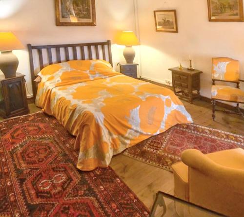 - une chambre avec un lit et une couette en orange dans l'établissement Appartement charmant à Sainte-Croix-du-Mont avec jardin, à Sainte-Croix-du-Mont