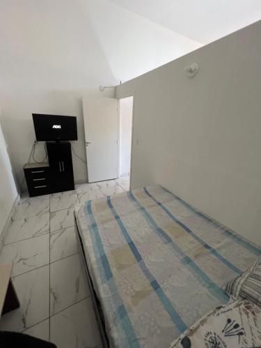 ein Schlafzimmer mit Bett und Flachbildfernseher in der Unterkunft Casa MR Brutomesso 2 in Londrina