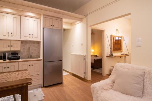 a kitchen with a refrigerator and a chair in a room at Sokaki Guesthouse in Arachova