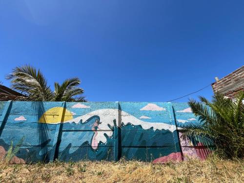 a fence with a mural of a shark on it at SURFHOUSE Pichilemu in Pichilemu