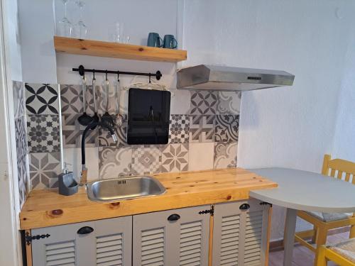 a kitchen with a sink and a counter with a table at Eleana Apartments in Hersonissos