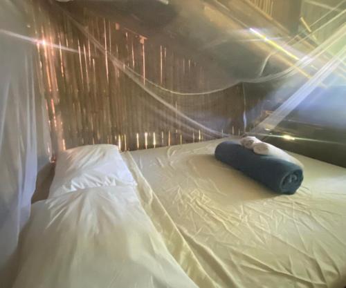 a small bed in a tent with a pillow on it at Remo Hostel in Parati-Mirim