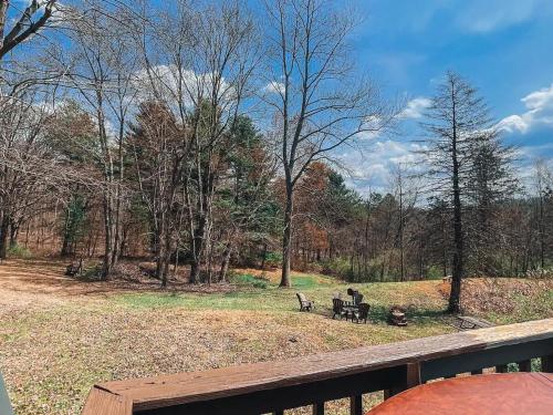 a person sitting on a picnic table in a park at Edgewater Escape, Hocking Hills, Hot Tub, Pond in Rockbridge