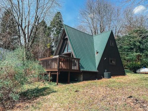 a house with a green roof and a deck at Edgewater Escape, Hocking Hills, Hot Tub, Pond in Rockbridge
