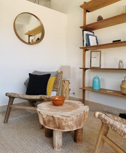 a living room with a table and a chair and a mirror at L'Atelier de Maison VB in Le Beausset